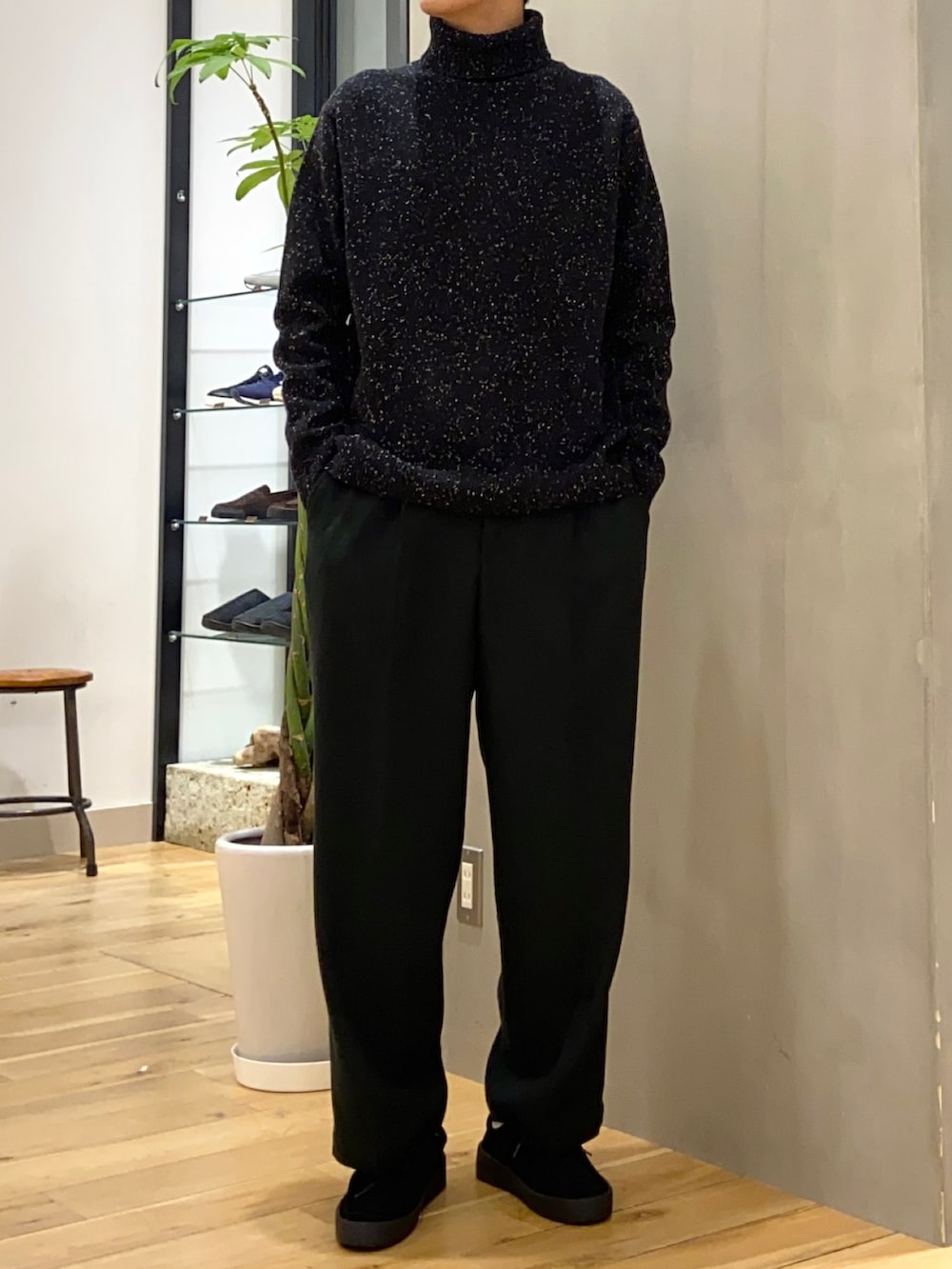 ブラウン系のモッズコート、ブラック系のニット/セーター、ブラック系のブーツを着用したメンズの冬コーディネートの2枚目の写真