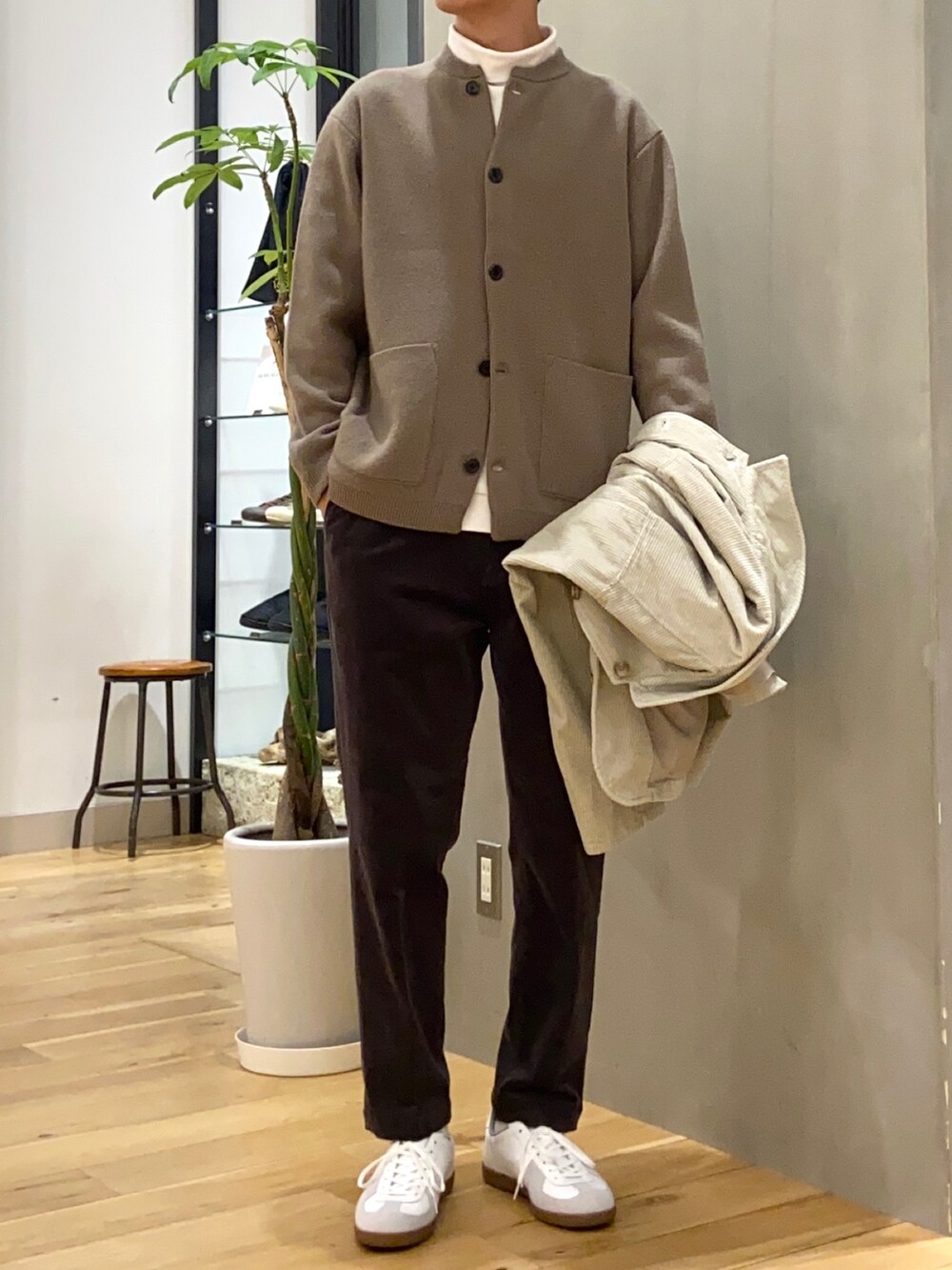 ホワイト系のカバーオール、ブラウン系のカーディガン/ボレロ、ブラウン系のその他パンツを着用したメンズの秋コーディネートの2枚目の写真