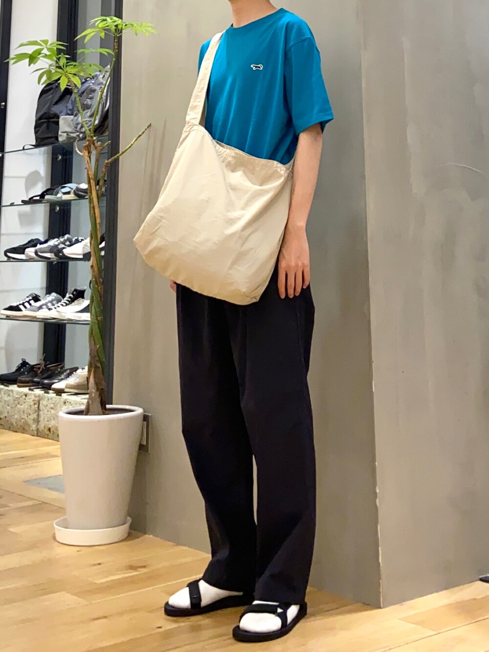 グレー系のショルダーバッグ、ブルー系のその他パンツ、ブラック系のサンダルを着用したメンズの春コーディネートの2枚目の写真