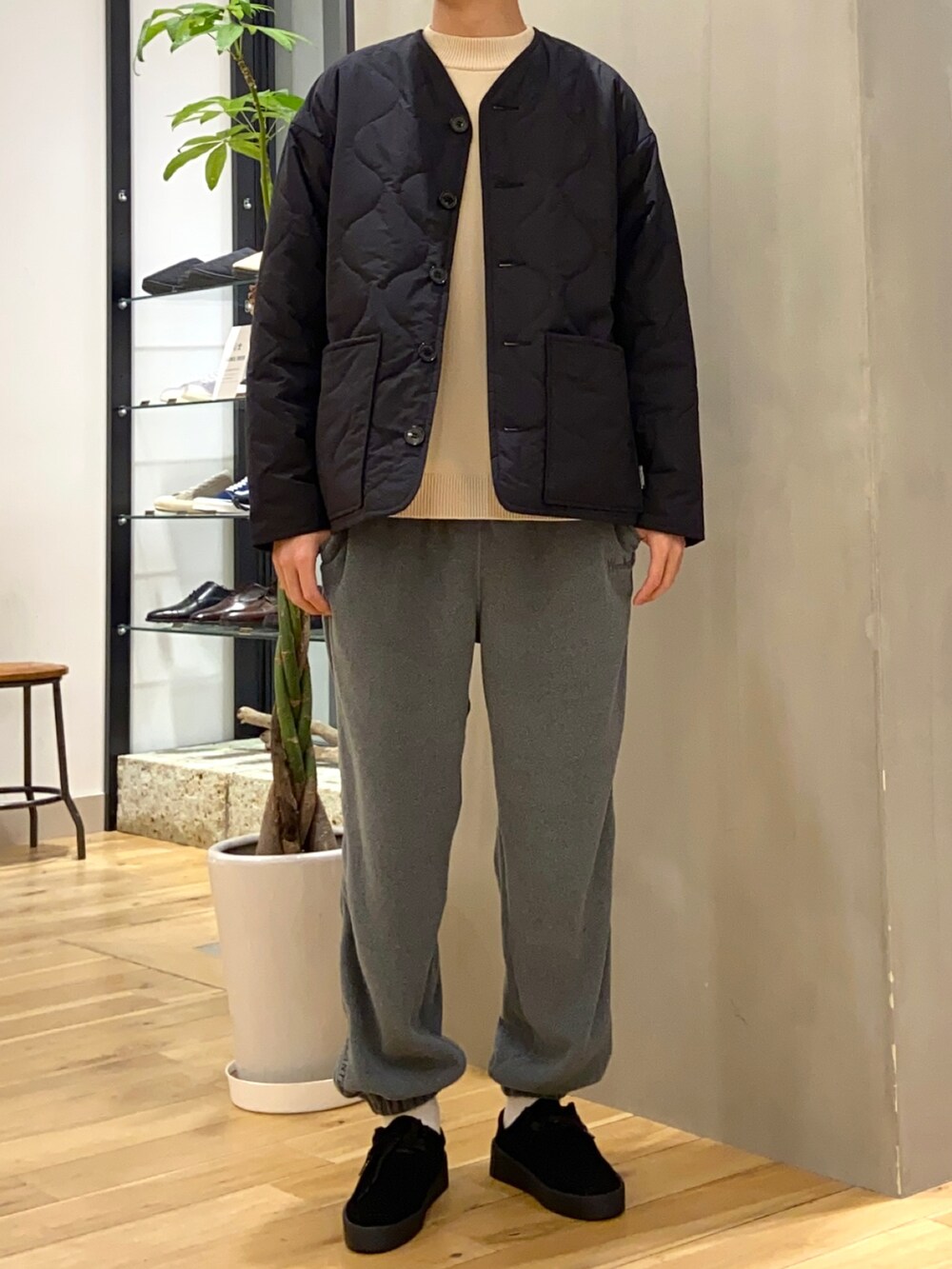 ブラック系のブルゾン、ホワイト系のニット/セーター、ブラック系のブーツを着用したメンズの冬コーディネートの3枚目の写真
