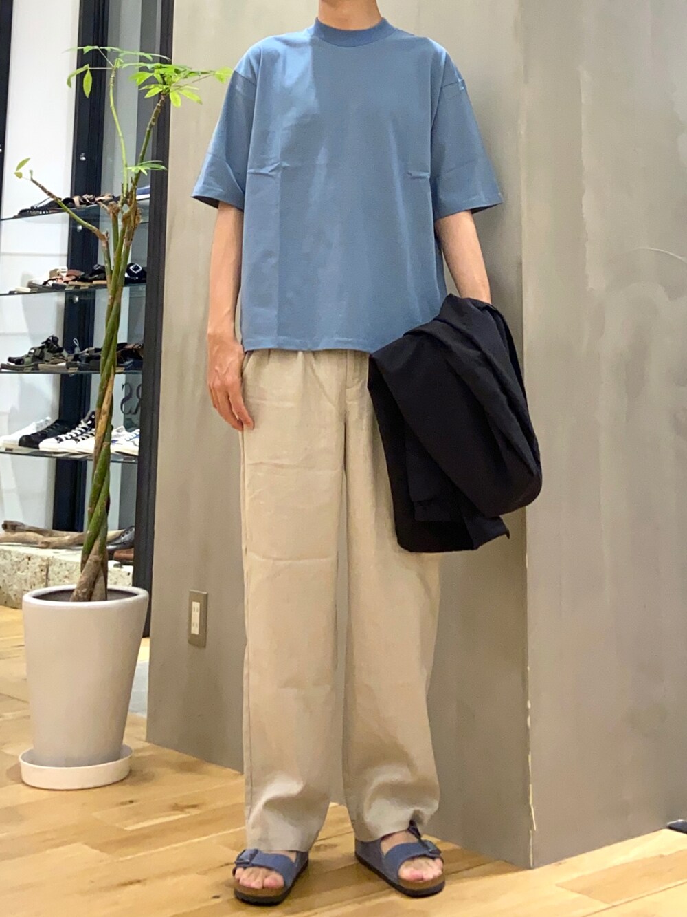 ブラック系のブルゾン、ベージュ系のその他パンツ、ブルー系のサンダルを着用したメンズの夏コーディネートの2枚目の写真