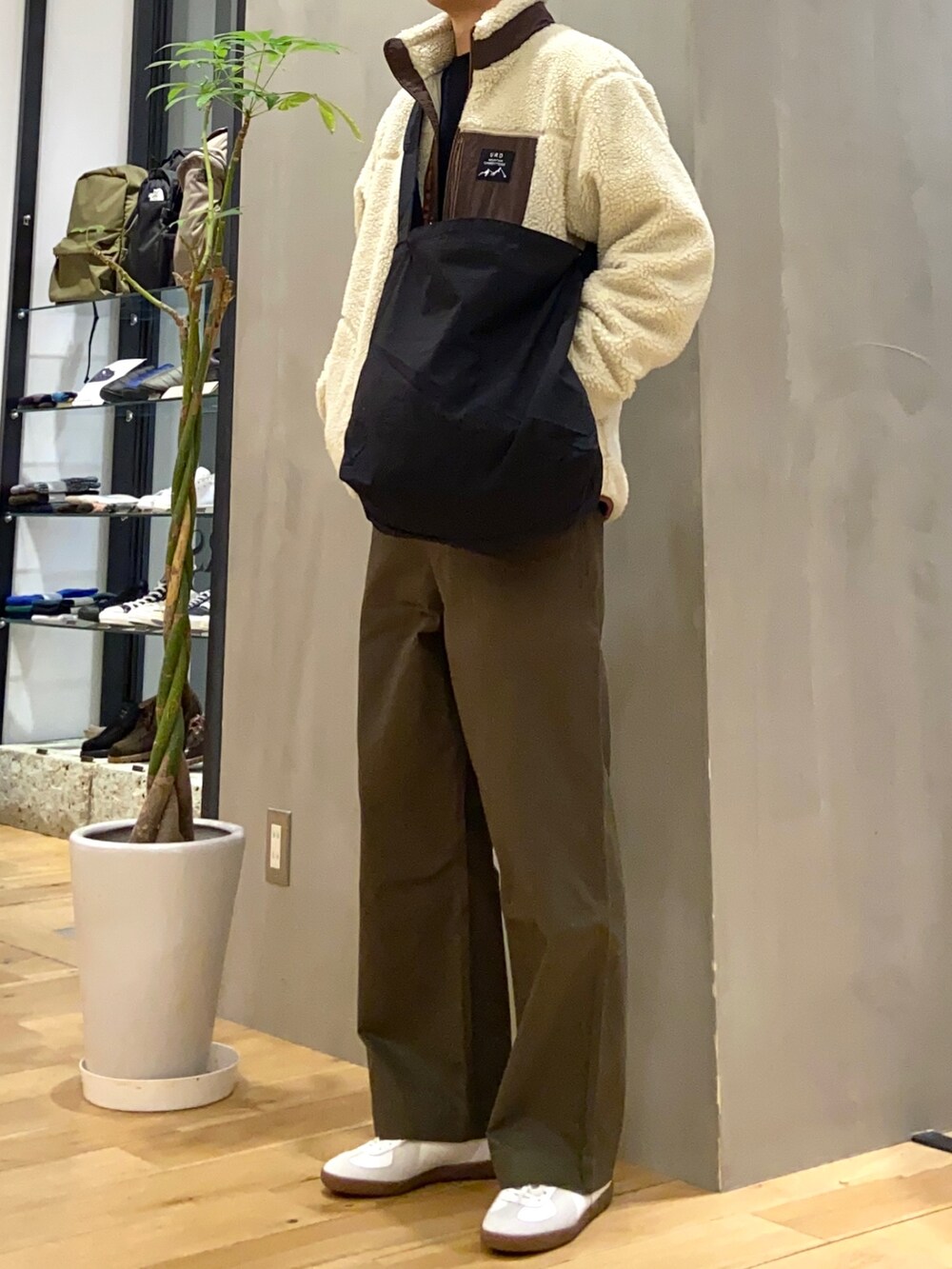 ベージュ系のブルゾン、ブラック系のショルダーバッグ、グリーン系のその他パンツを着用したメンズの冬コーディネートの2枚目の写真