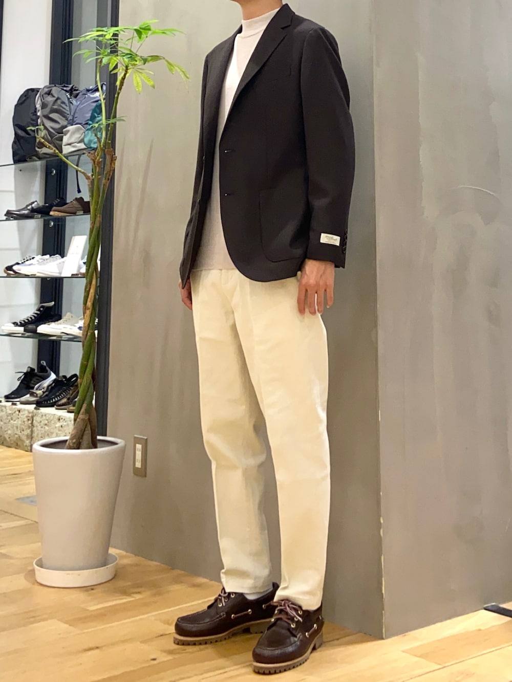 ブラウン系のその他アウター、ホワイト系のニット/セーター、ホワイト系のチノパンツを着用したメンズの秋コーディネートの3枚目の写真