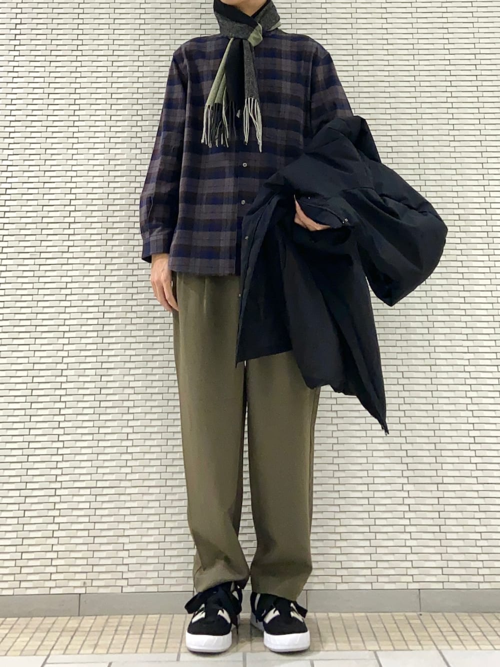 ブラック系のダウンジャケット/コート、ブラウン系のシャツ/ブラウス、グレー系のその他パンツを着用したメンズの冬コーディネートの2枚目の写真