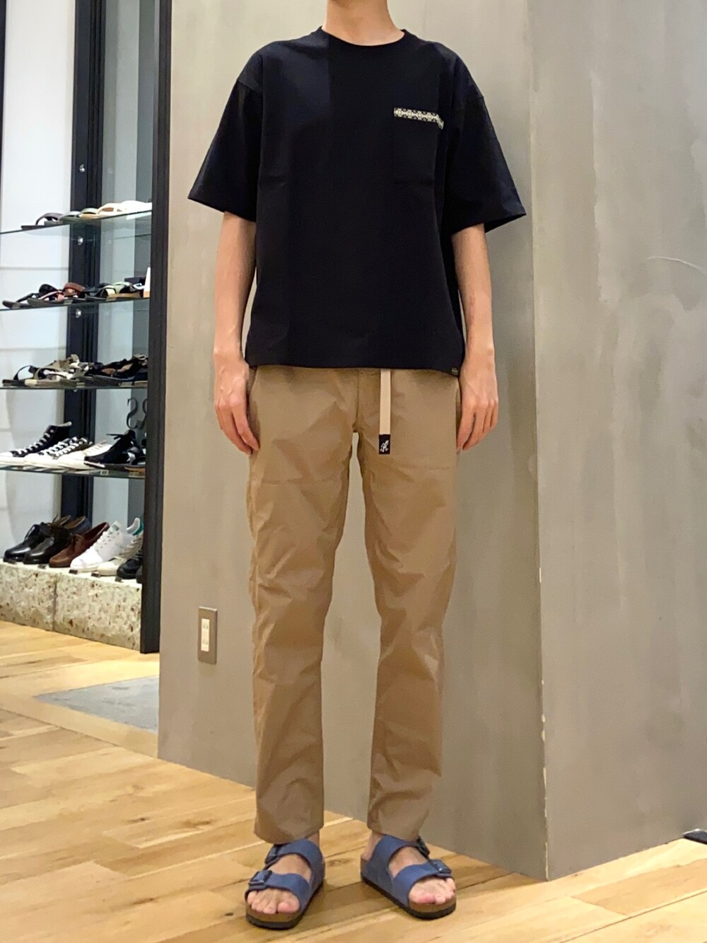 ブラック系のTシャツ/カットソー、ベージュ系のその他パンツ、ブルー系のサンダルを着用したメンズの夏コーディネートの3枚目の写真