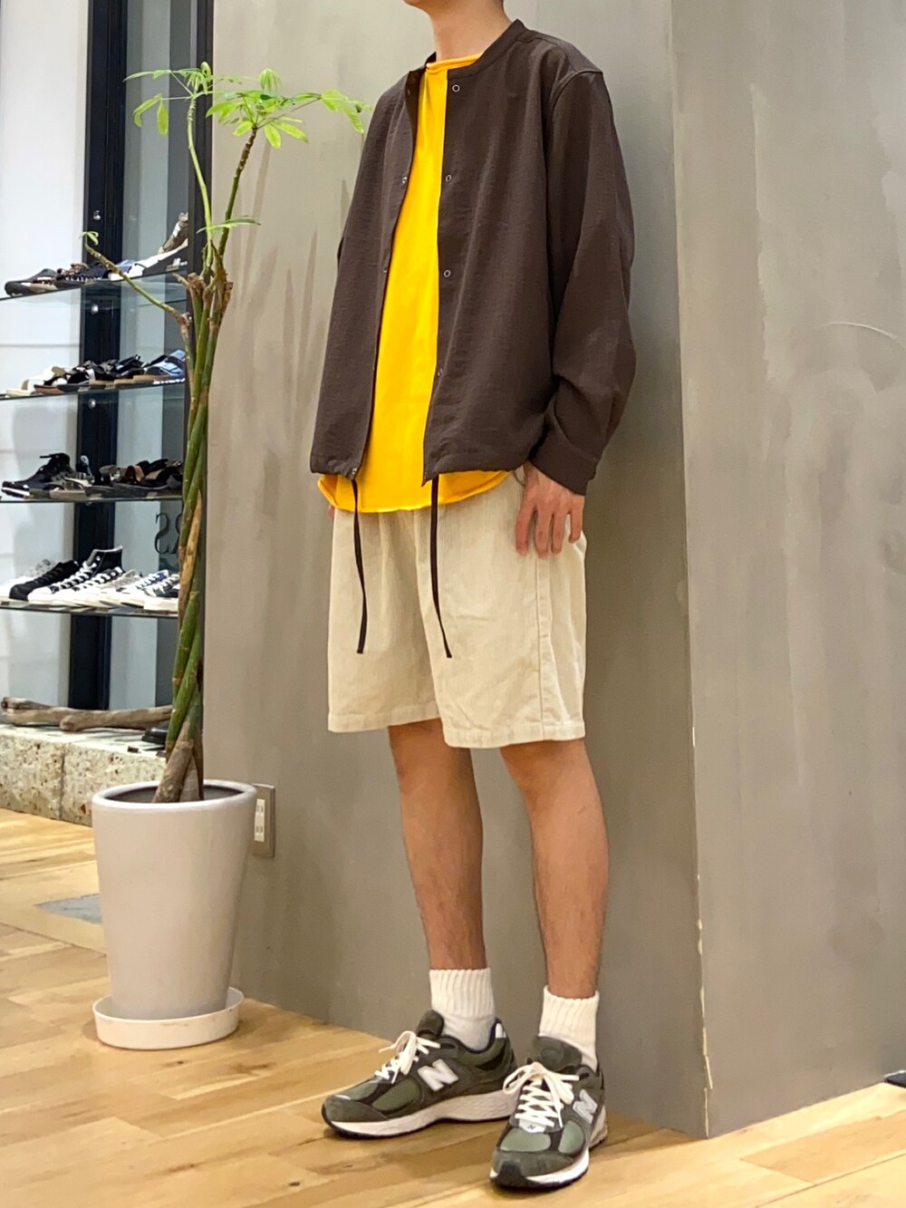 ブラウン系のブルゾン、イエロー系のTシャツ/カットソー、ホワイト系のその他パンツを着用したメンズの夏コーディネートの3枚目の写真