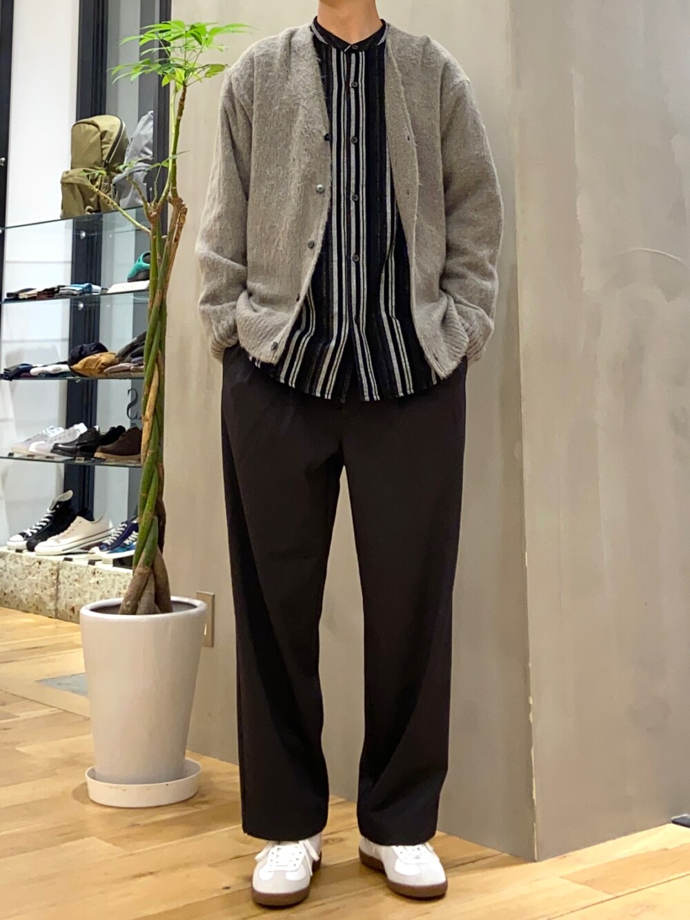 グレー系のカーディガン/ボレロ、ブラック系のシャツ/ブラウス、ホワイト系のスニーカーを着用したメンズの秋コーディネートの2枚目の写真