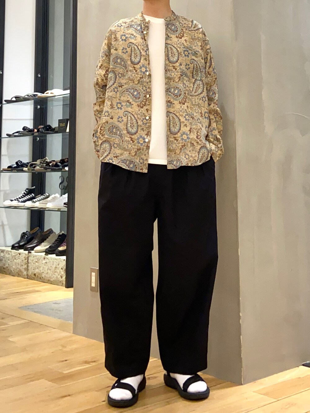 ブラウン系のシャツ/ブラウス、ホワイト系のTシャツ/カットソー、ブラック系のサンダルを着用したメンズの春コーディネートの2枚目の写真