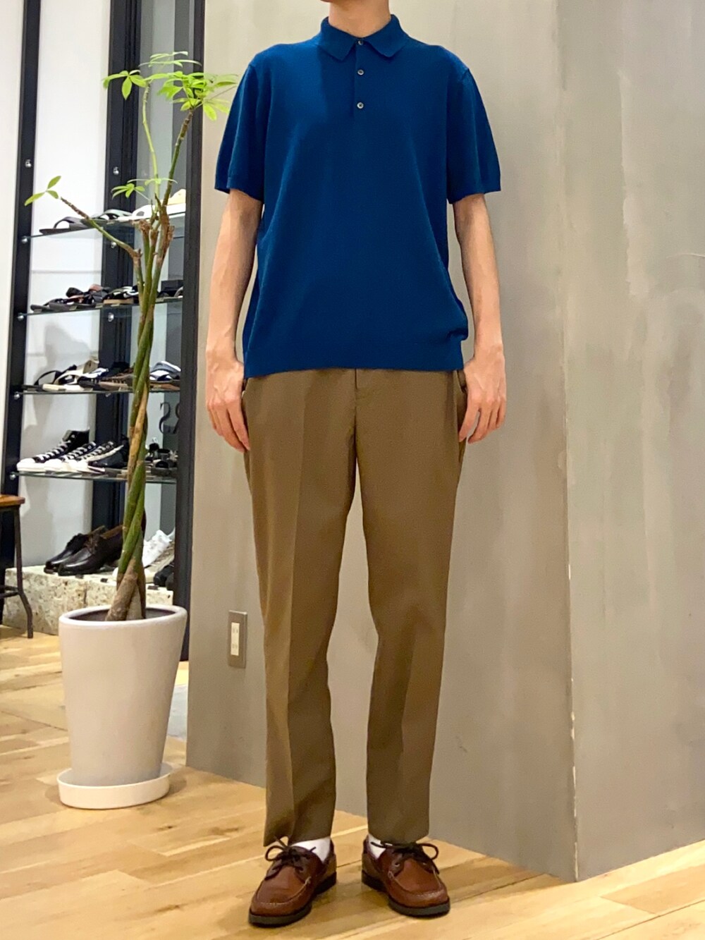 ブルー系のポロシャツ、ブラウン系のその他パンツを着用したメンズの夏コーディネートの3枚目の写真