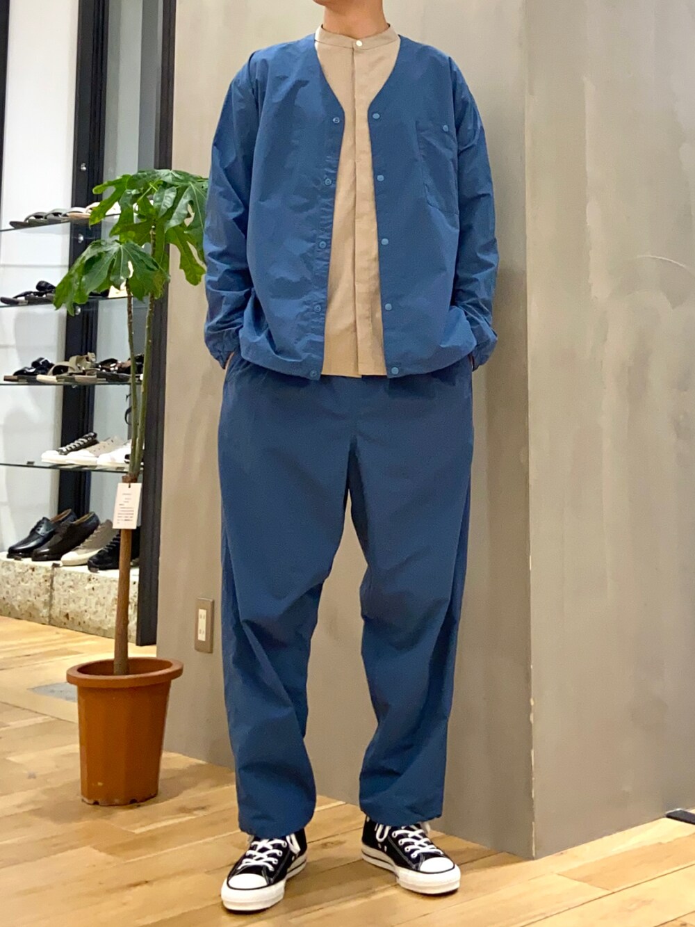 ベージュ系のシャツ/ブラウス、ブルー系のナイロンジャケット、ブルー系のその他パンツを着用したメンズの春コーディネートの2枚目の写真
