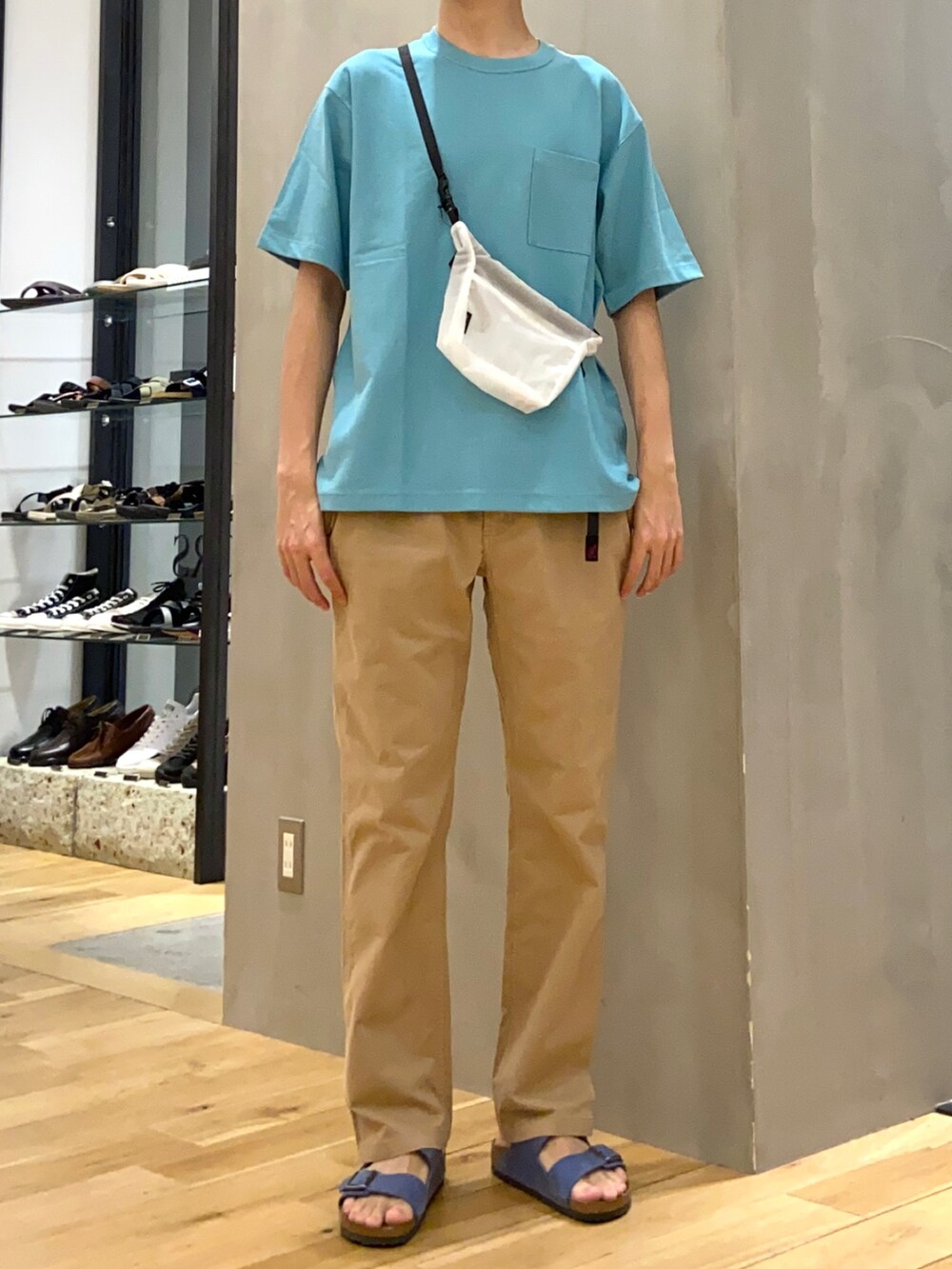 ブルー系のTシャツ/カットソー、ホワイト系のショルダーバッグ、ブルー系のサンダルを着用したメンズの春コーディネートの3枚目の写真