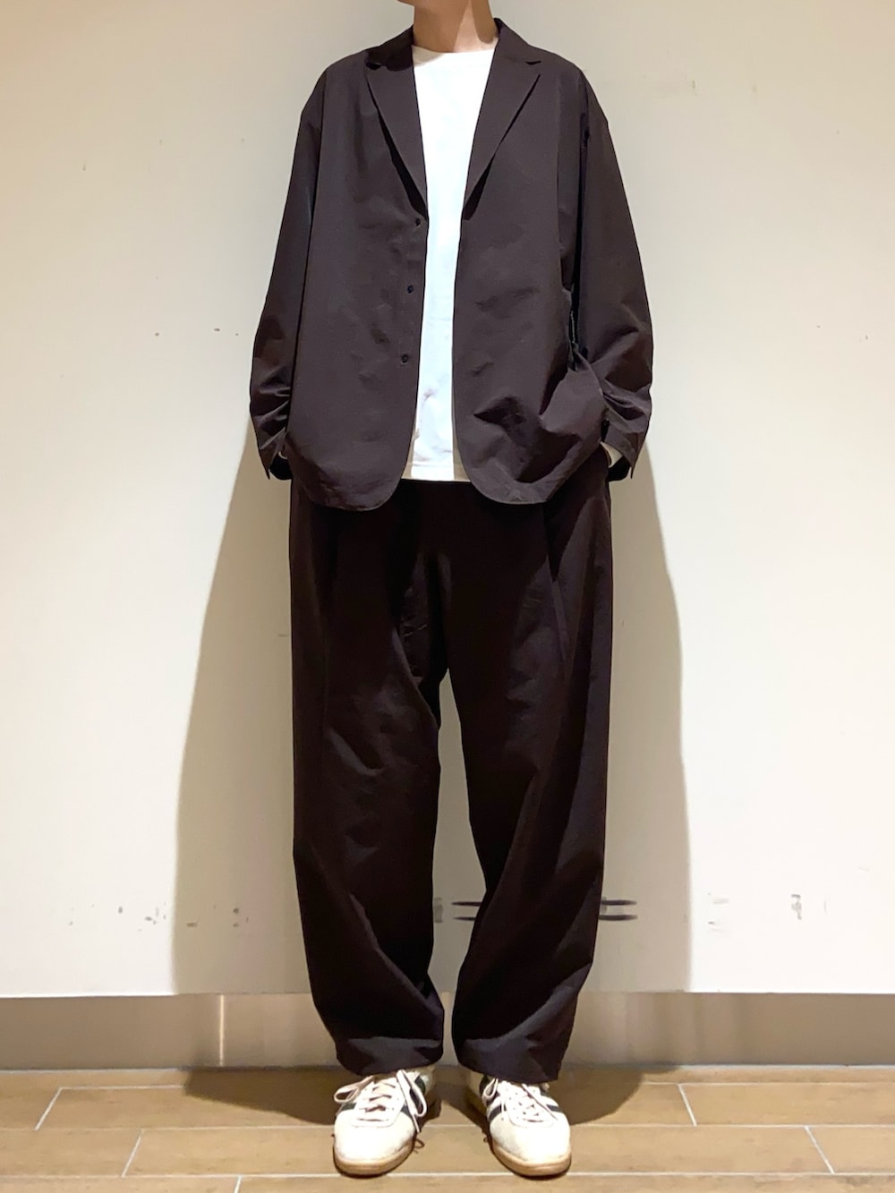 ブラウン系のその他アウター、ブラウン系のその他パンツ、ホワイト系のTシャツ/カットソーを着用したメンズの春コーディネートの3枚目の写真