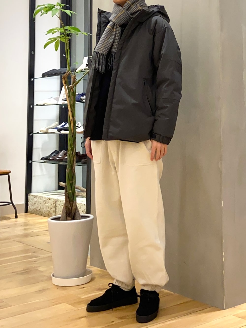グレー系のダウンジャケット/コート、ホワイト系のその他パンツ、ブラック系のその他シューズを着用したメンズの冬コーディネートの4枚目の写真