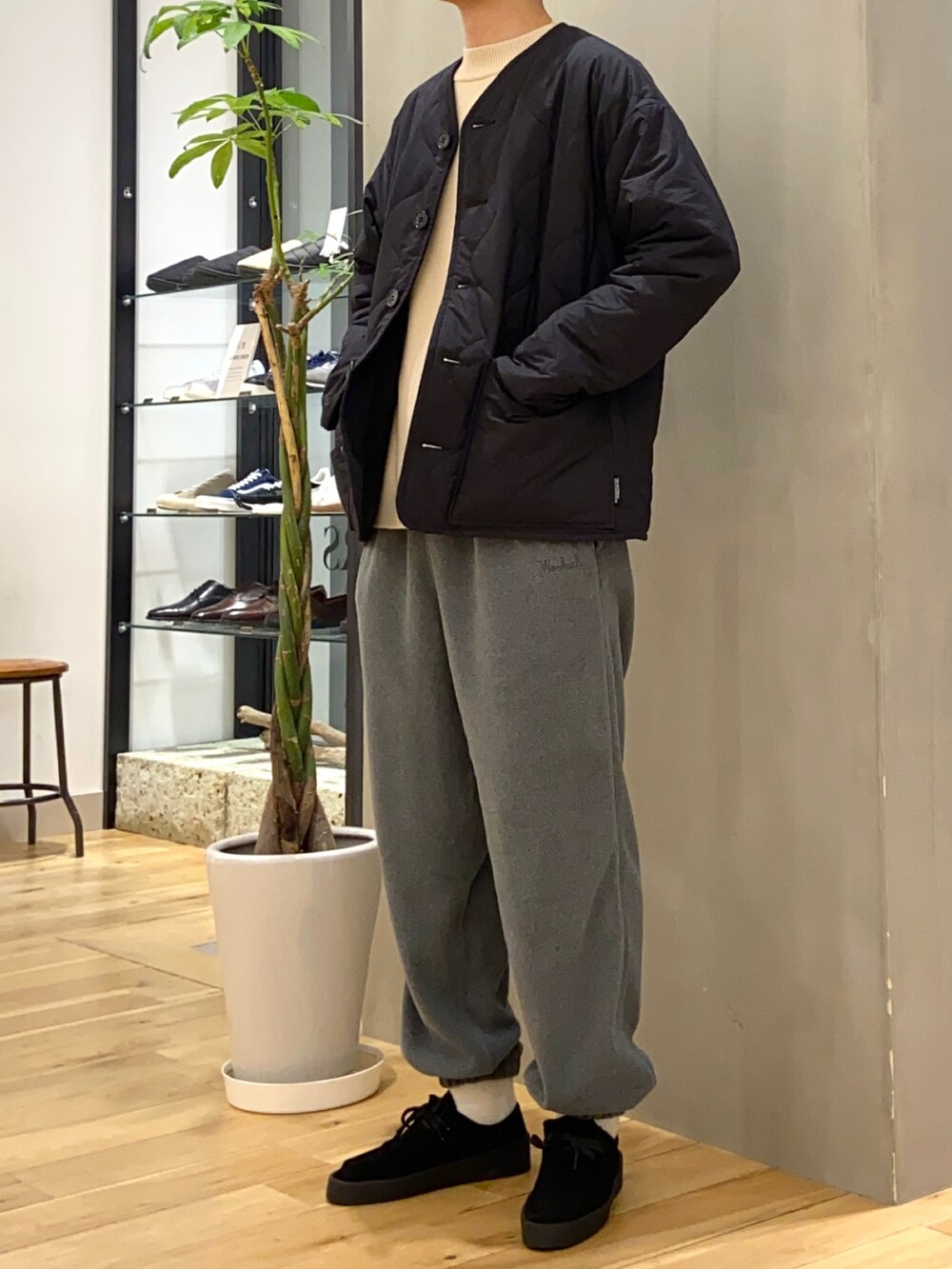 ブラック系のブルゾン、ホワイト系のニット/セーター、ブラック系のブーツを着用したメンズの冬コーディネートの2枚目の写真