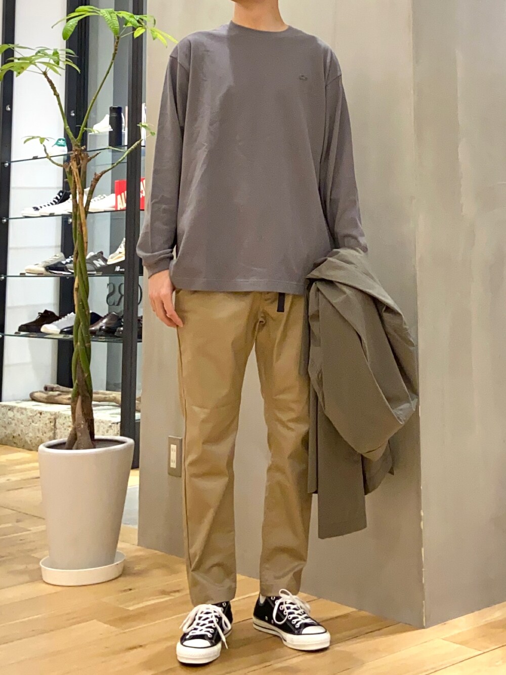 グレー系のTシャツ/カットソー、グリーン系のステンカラーコート、ベージュ系のその他パンツを着用したメンズの春コーディネートの4枚目の写真