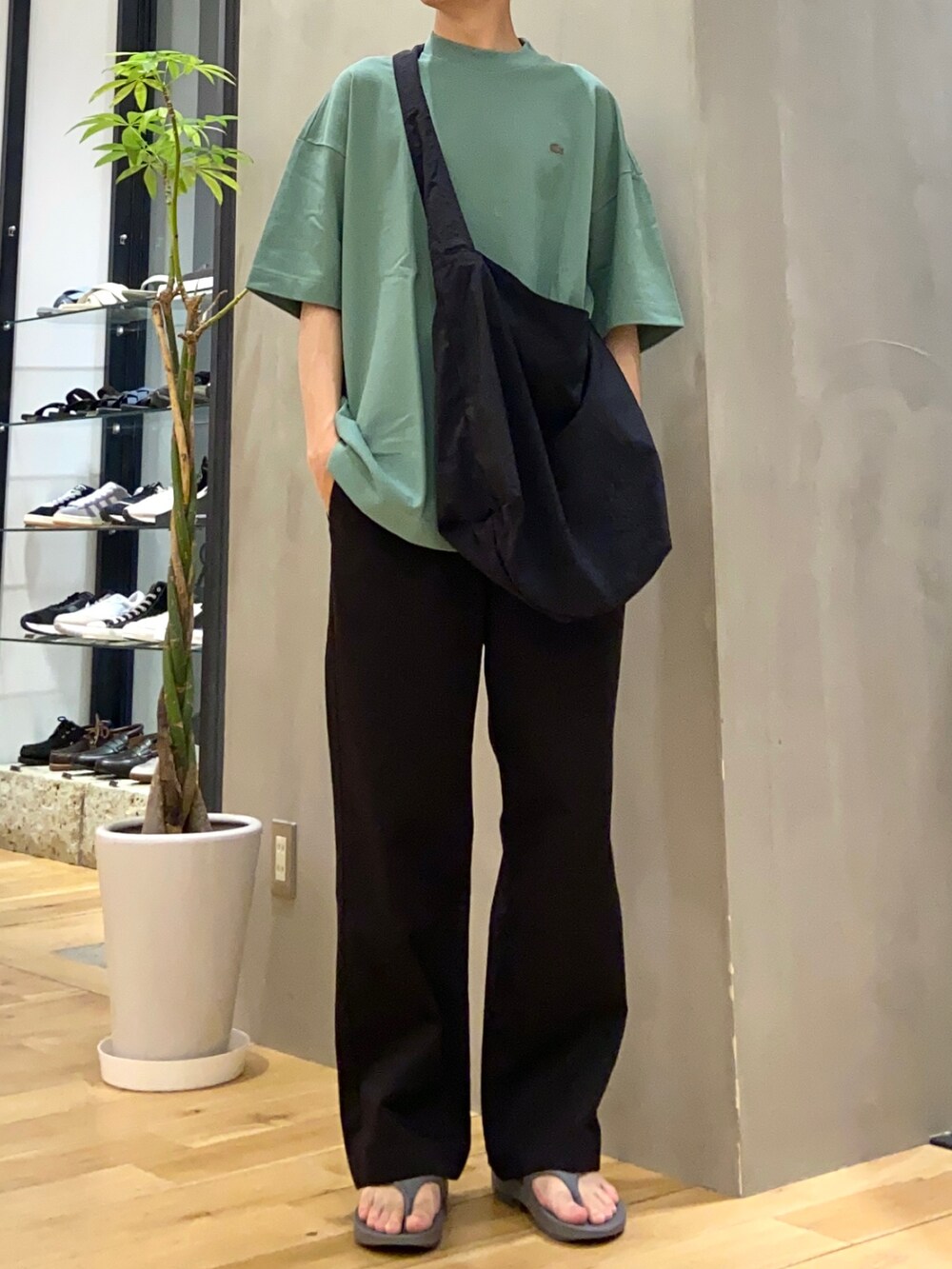 グリーン系のTシャツ/カットソー、ブラック系のショルダーバッグ、ブラック系のその他パンツを着用したメンズの春コーディネートの3枚目の写真