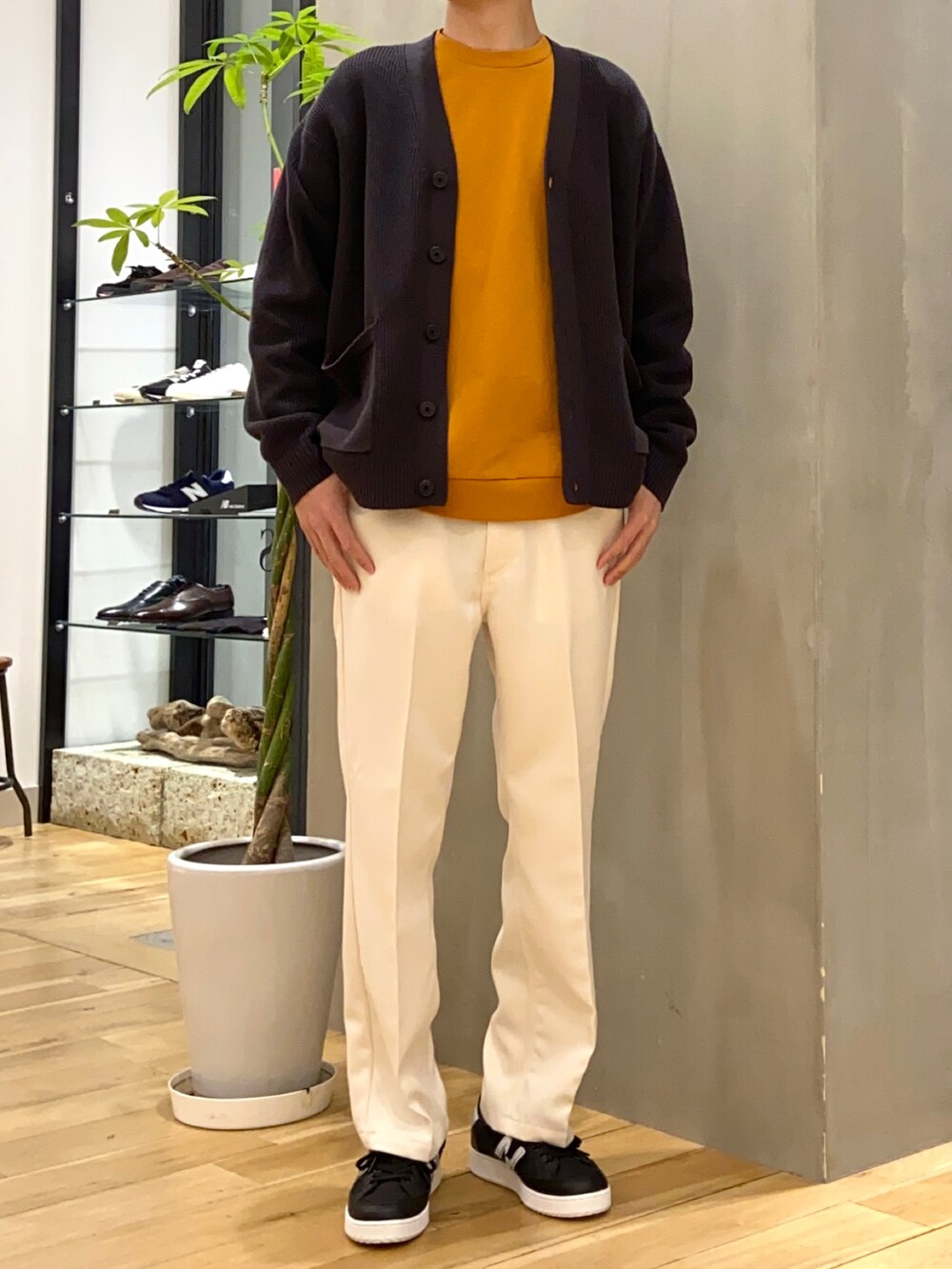 グレー系のカーディガン/ボレロ、オレンジ系のTシャツ/カットソー、ブラック系のスニーカーを着用したメンズの冬コーディネートの3枚目の写真