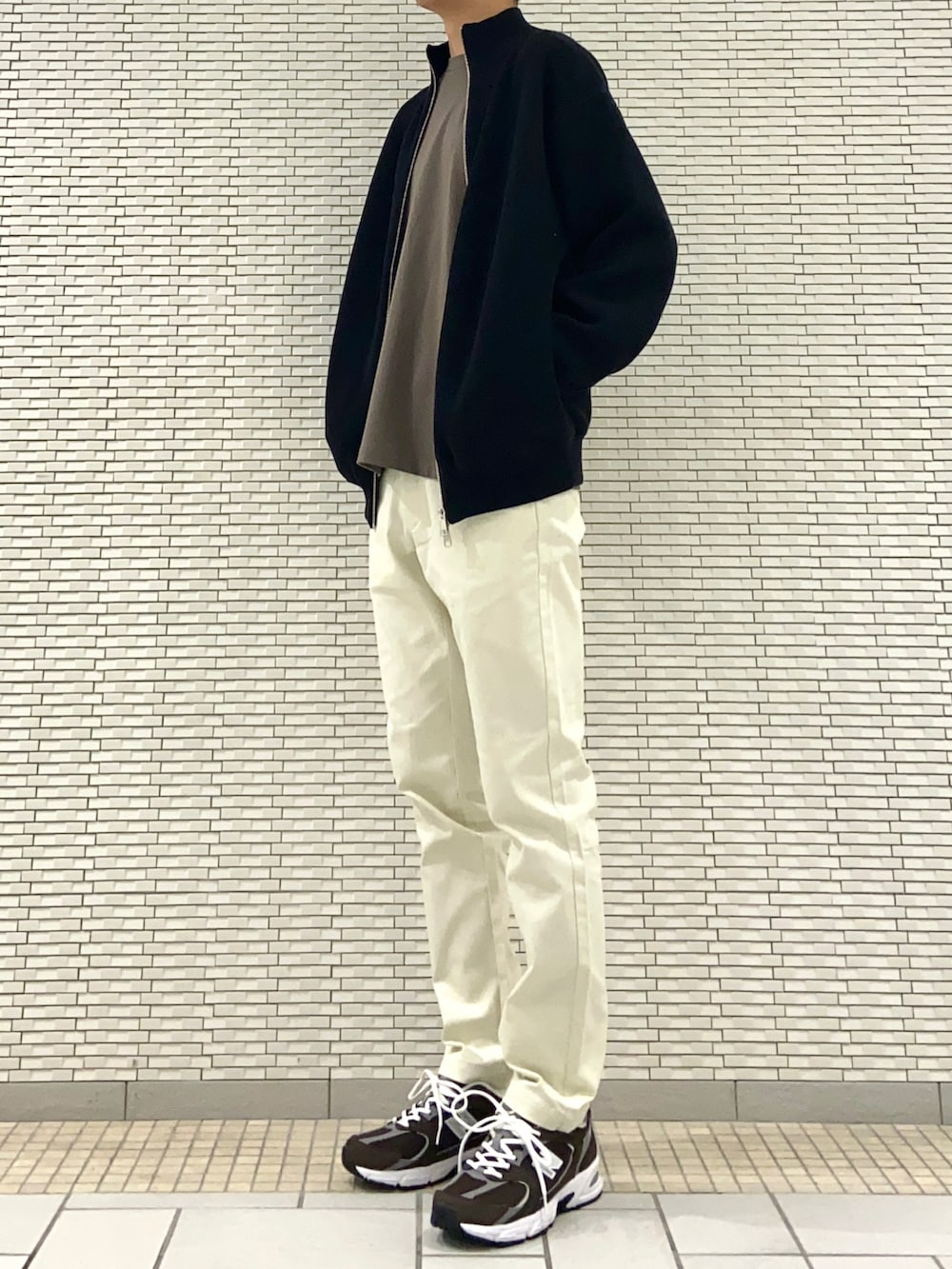 ブラック系のブルゾン、ブラウン系のTシャツ/カットソー、ホワイト系のその他パンツを着用したメンズの秋コーディネートの3枚目の写真