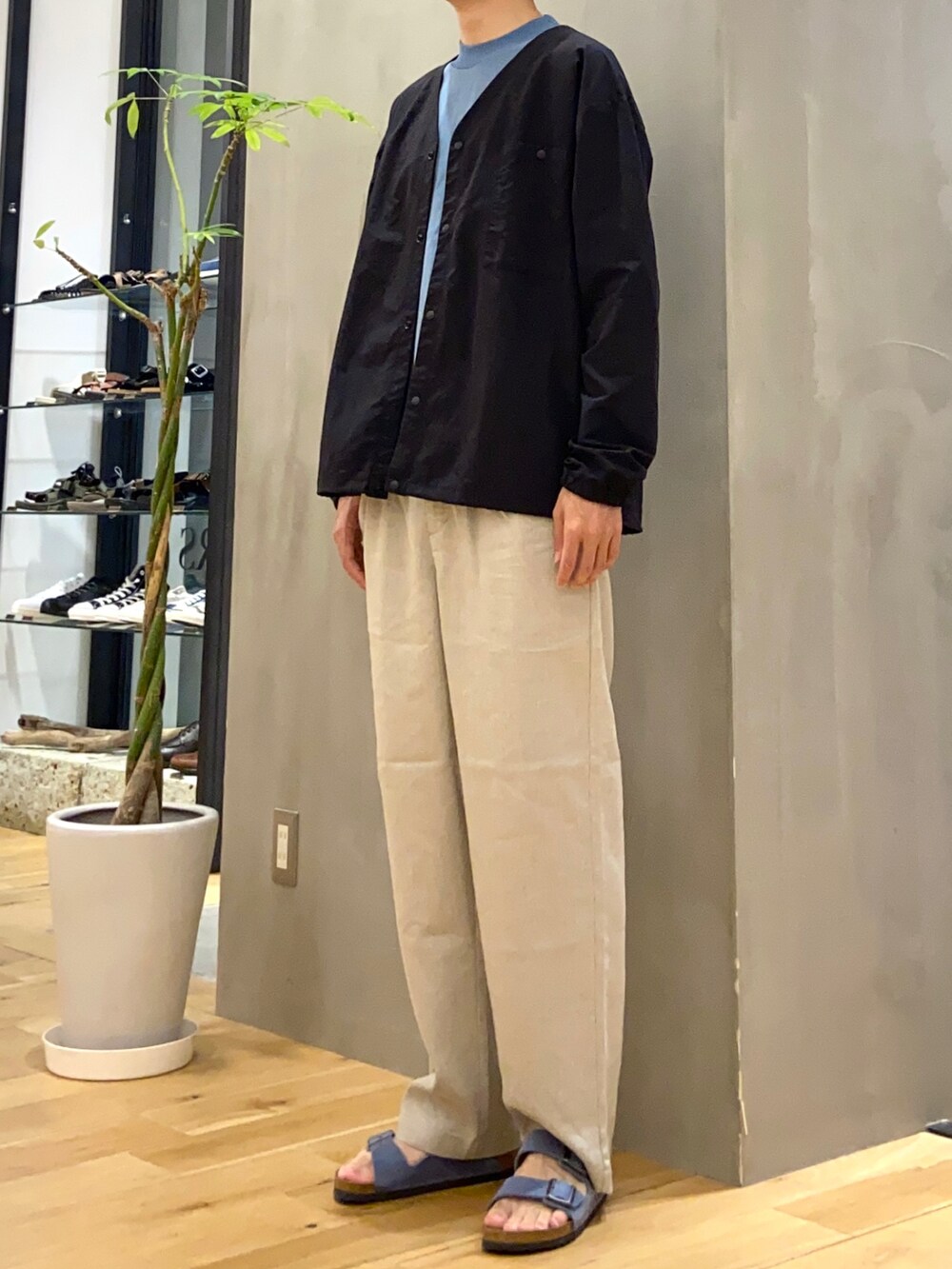 ブラック系のブルゾン、ベージュ系のその他パンツ、ブルー系のサンダルを着用したメンズの夏コーディネートの3枚目の写真