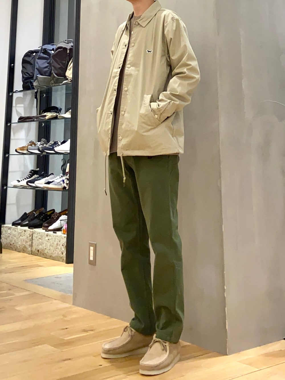 ベージュ系のその他アウター、グリーン系のその他パンツ、ブラウン系のTシャツ/カットソーを着用したメンズの春コーディネートの3枚目の写真