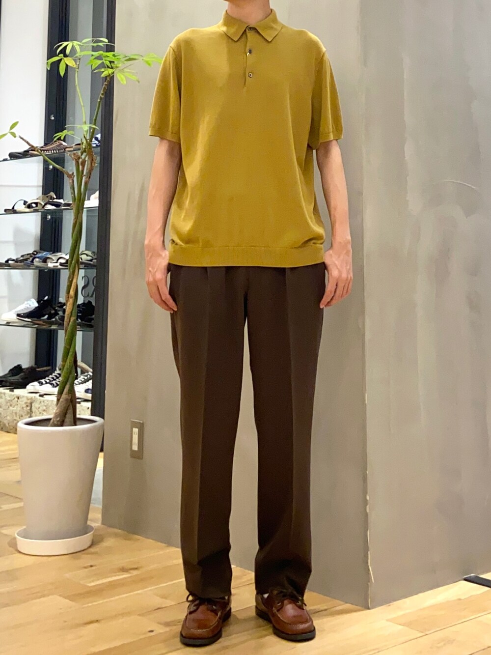イエロー系のポロシャツ、ブラウン系のその他パンツを着用したメンズの夏コーディネートの2枚目の写真