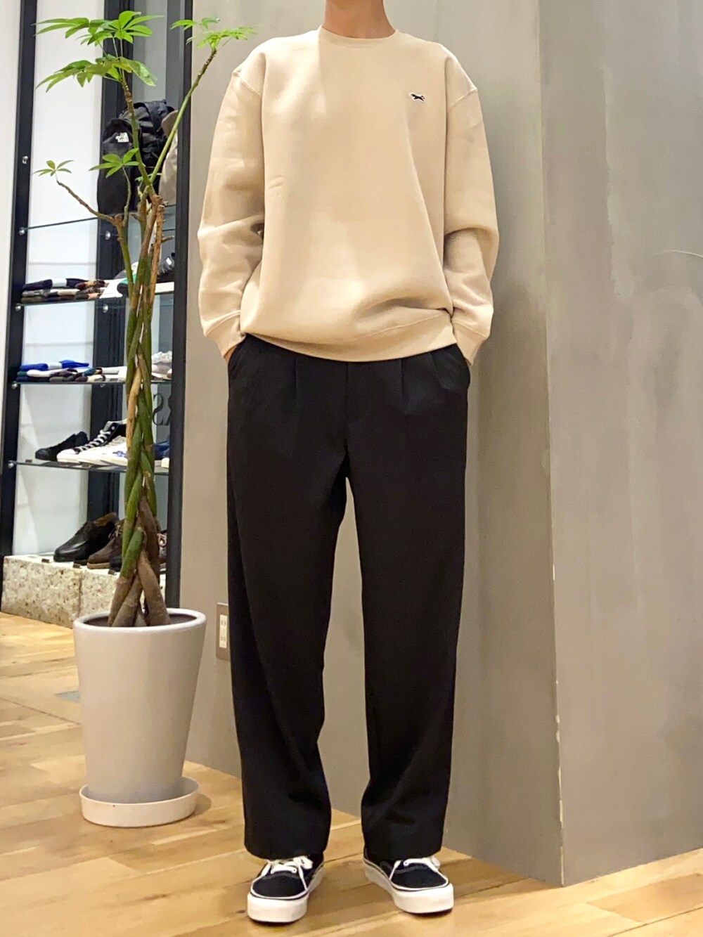 グリーン系のダウンジャケット/コート、ベージュ系のスウェット、ブラック系のスニーカーを着用したメンズの冬コーディネートの2枚目の写真