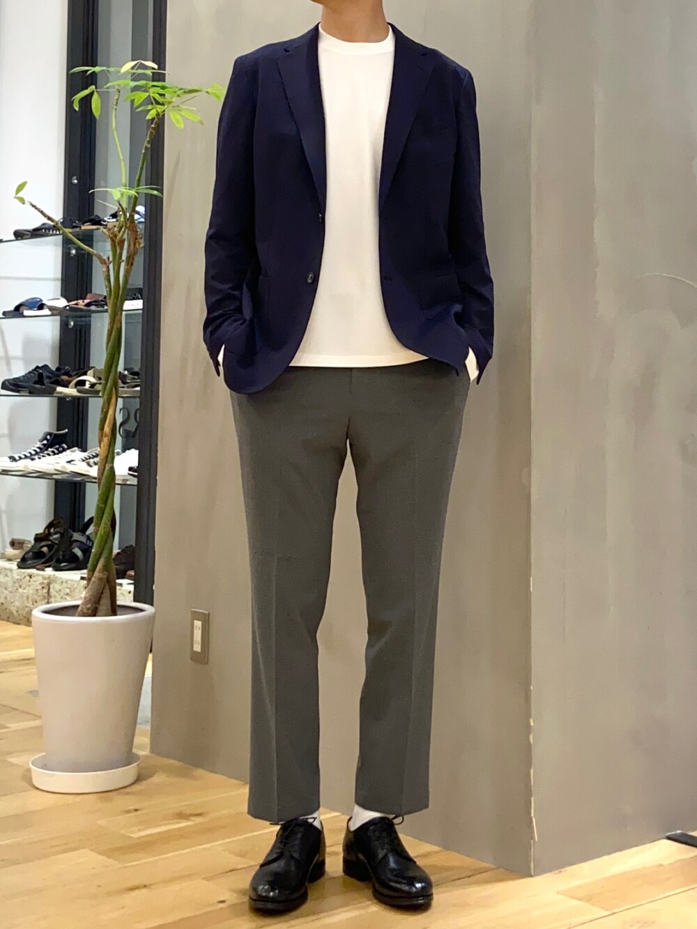 ブルー系のスーツジャケット、グレー系のスーツパンツ、ブラック系のドレスシューズを着用したメンズの夏コーディネートの2枚目の写真