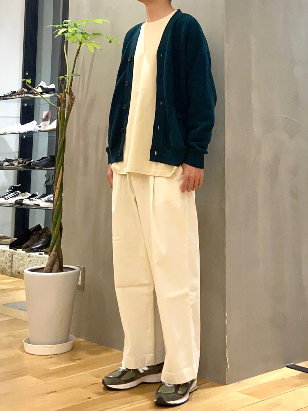 グリーン系のカーディガン/ボレロ、ベージュ系のTシャツ/カットソー、ホワイト系のチノパンツを着用したメンズの夏コーディネートの3枚目の写真