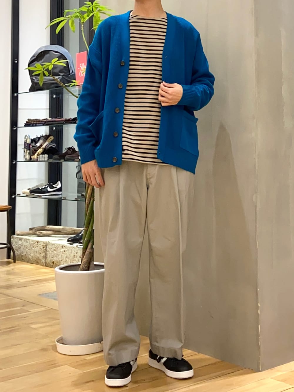 ブルー系のカーディガン/ボレロ、ブラック系のTシャツ/カットソー、ブラック系のスニーカーを着用したメンズの冬コーディネートの3枚目の写真