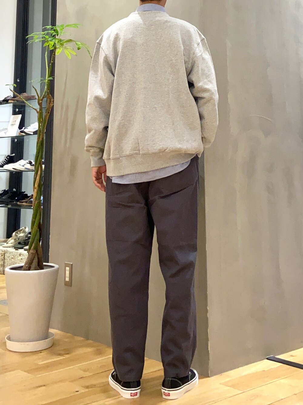 グレー系のカーディガン/ボレロ、ブルー系のシャツ/ブラウス、ブラック系のスニーカーを着用したメンズの秋コーディネートの3枚目の写真