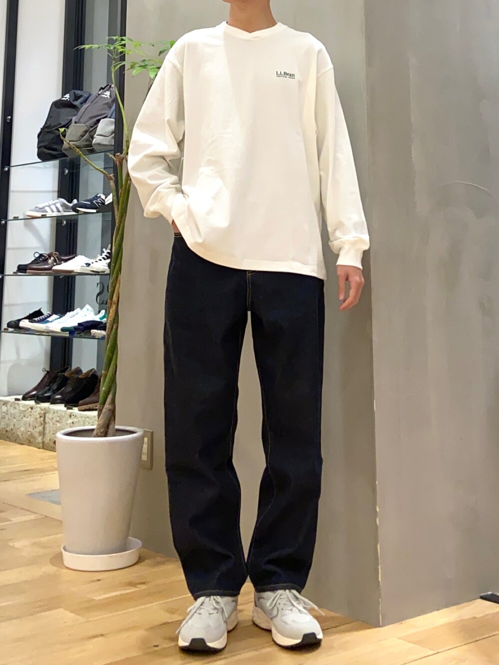 グリーン系のナイロンジャケット、ブルー系のデニムパンツ、グレー系のスニーカーを着用したメンズの春コーディネートの2枚目の写真