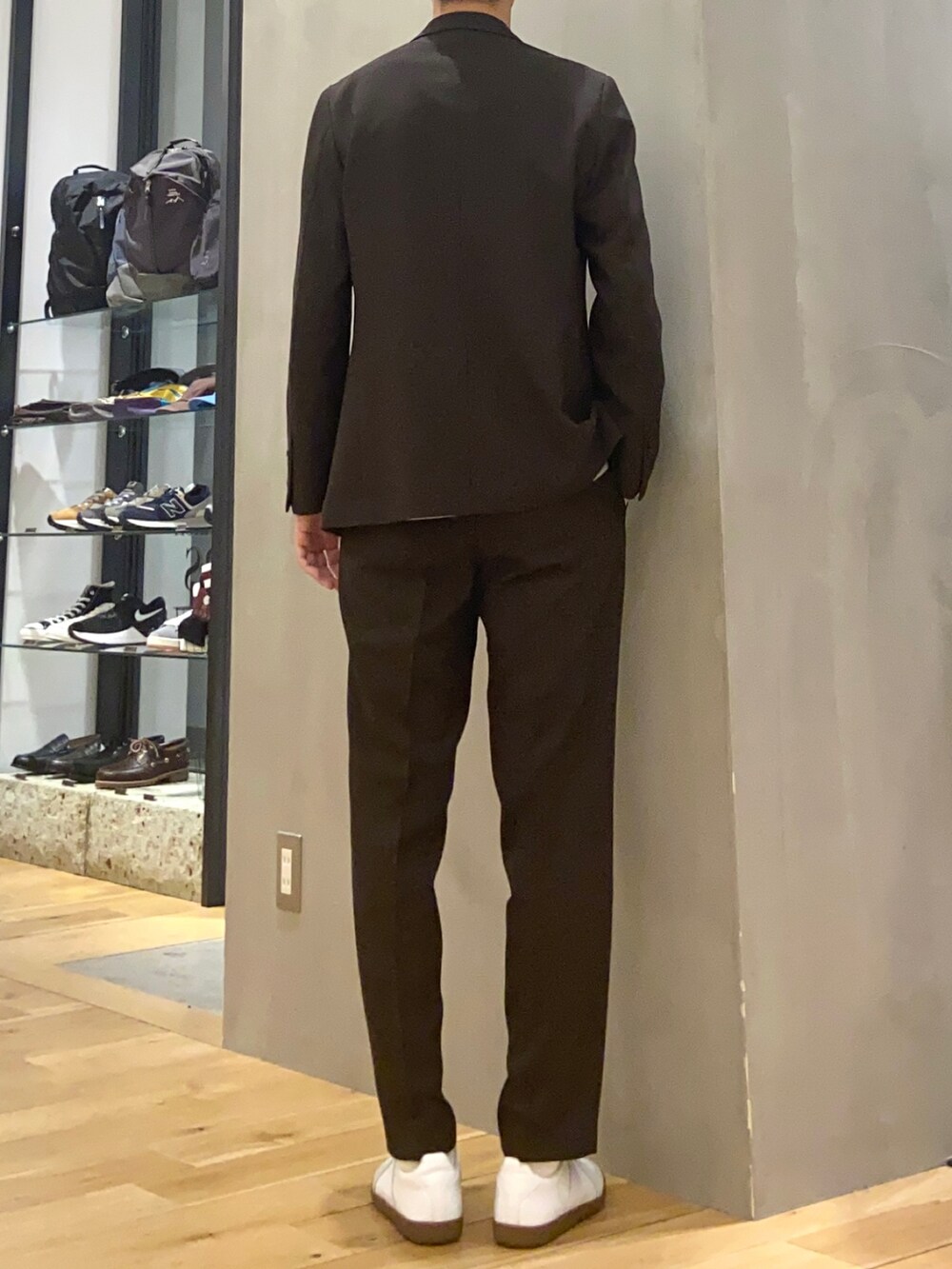 ブラウン系のスーツジャケット、ブルー系のTシャツ/カットソー、ブラウン系のスーツパンツを着用したメンズの春コーディネートの3枚目の写真