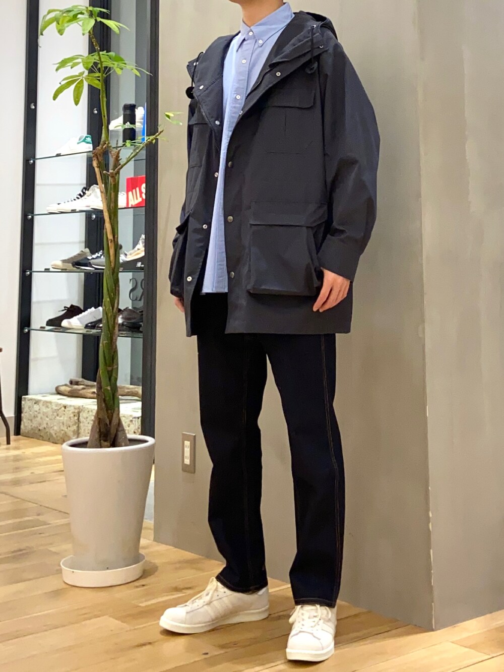 ブラック系のマウンテンパーカー、ブルー系のシャツ/ブラウス、ベージュ系のスニーカーを着用したメンズの春コーディネートの4枚目の写真