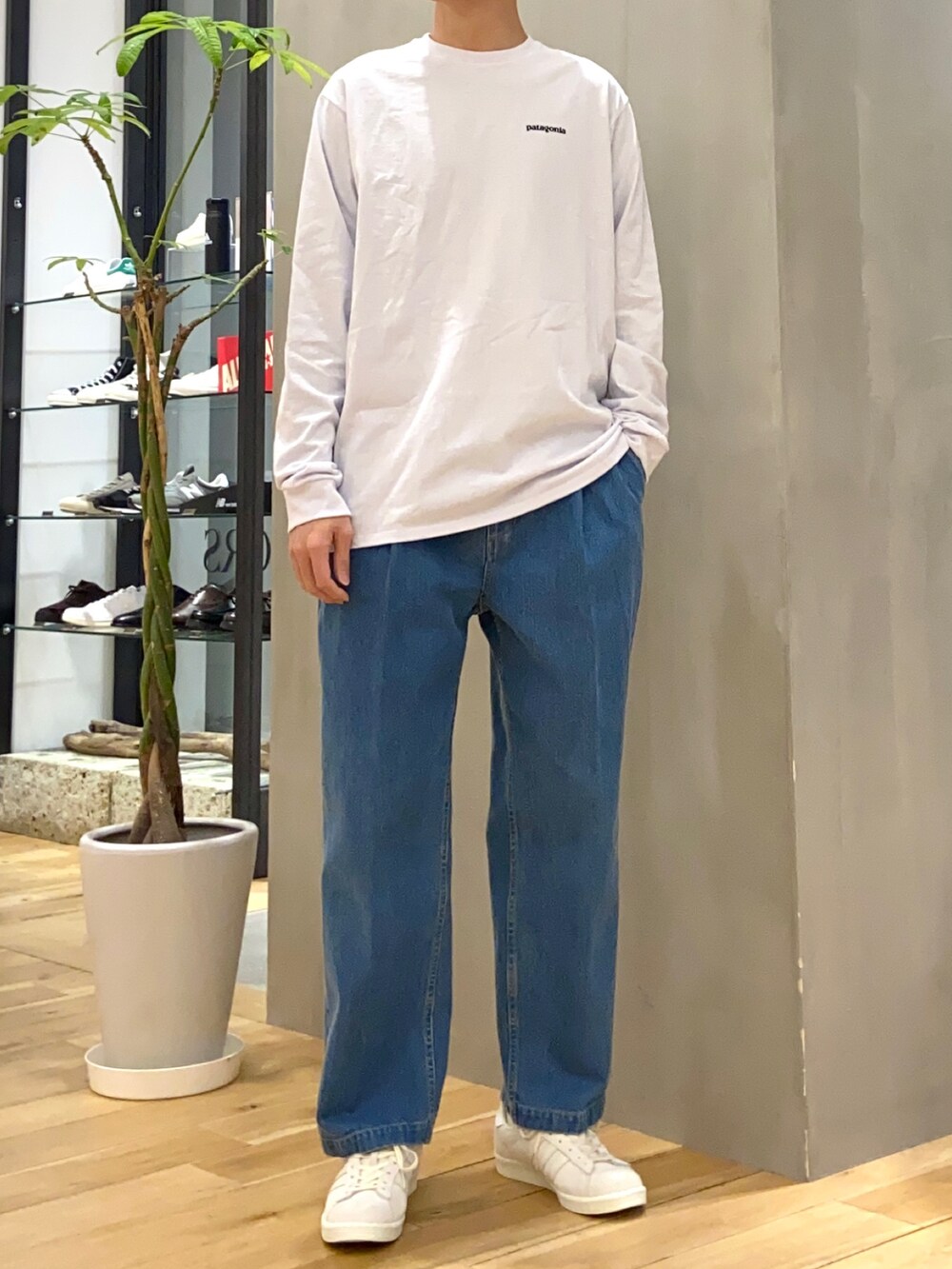 ブラック系のミリタリージャケット、ブルー系のデニムパンツ、ベージュ系のスニーカーを着用したメンズの春コーディネートの2枚目の写真