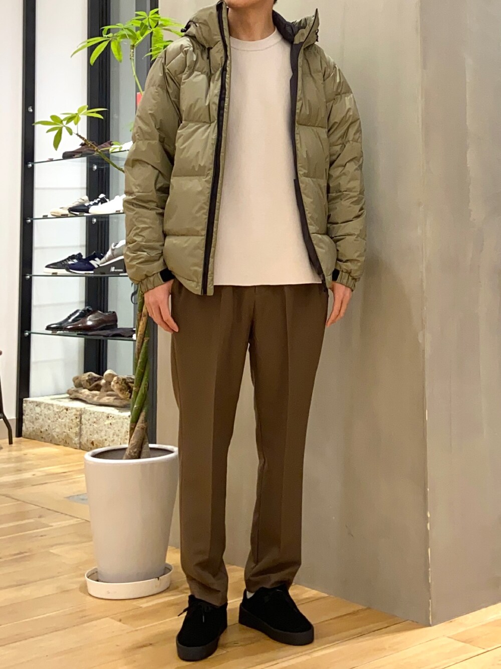 グリーン系のダウンジャケット/コート、ホワイト系のニット/セーター、ブラック系のその他シューズを着用したメンズの冬コーディネートの3枚目の写真