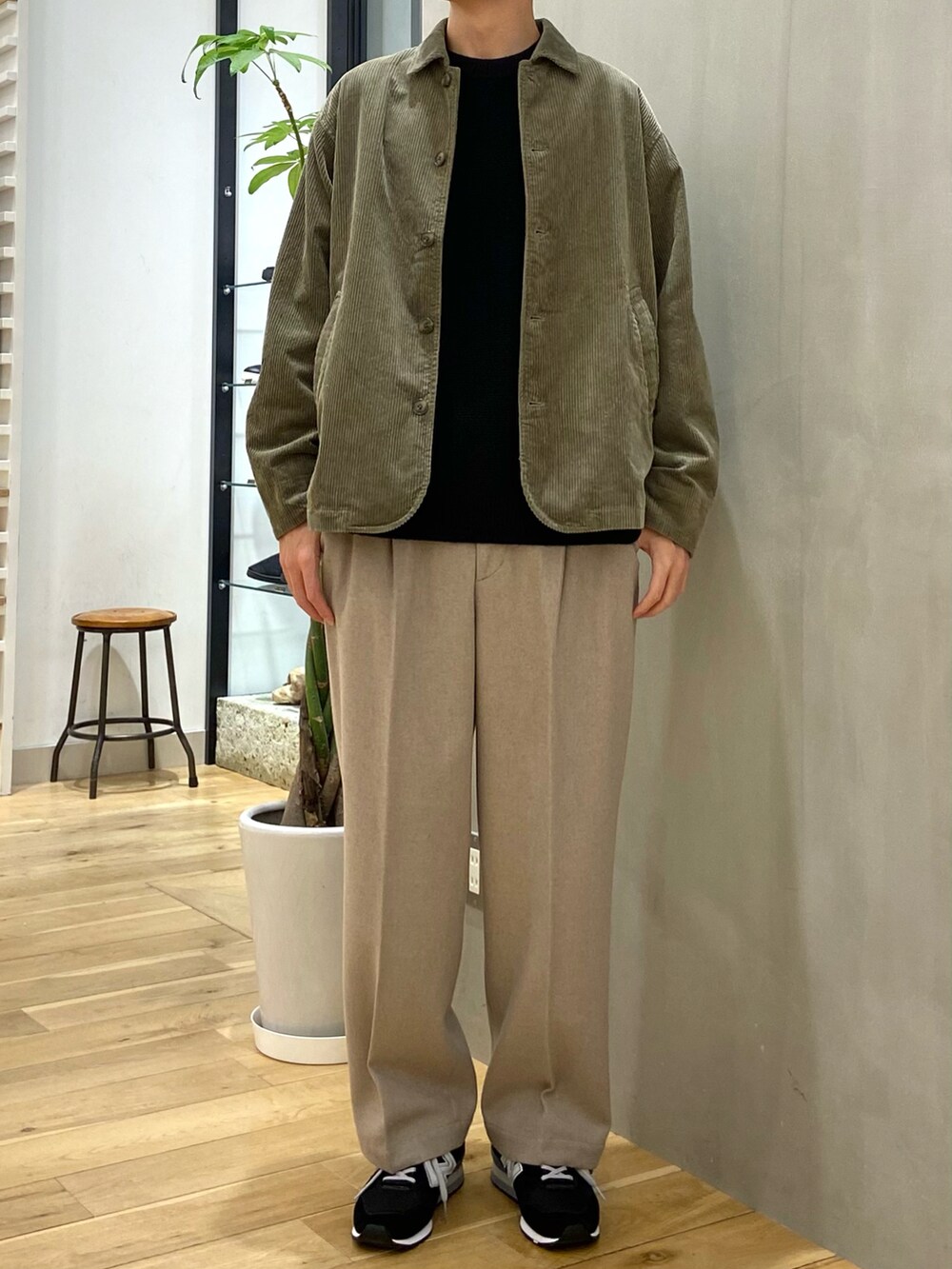 グリーン系のカバーオール、ブラック系のニット/セーター、ベージュ系のその他パンツを着用したメンズの秋コーディネートの3枚目の写真