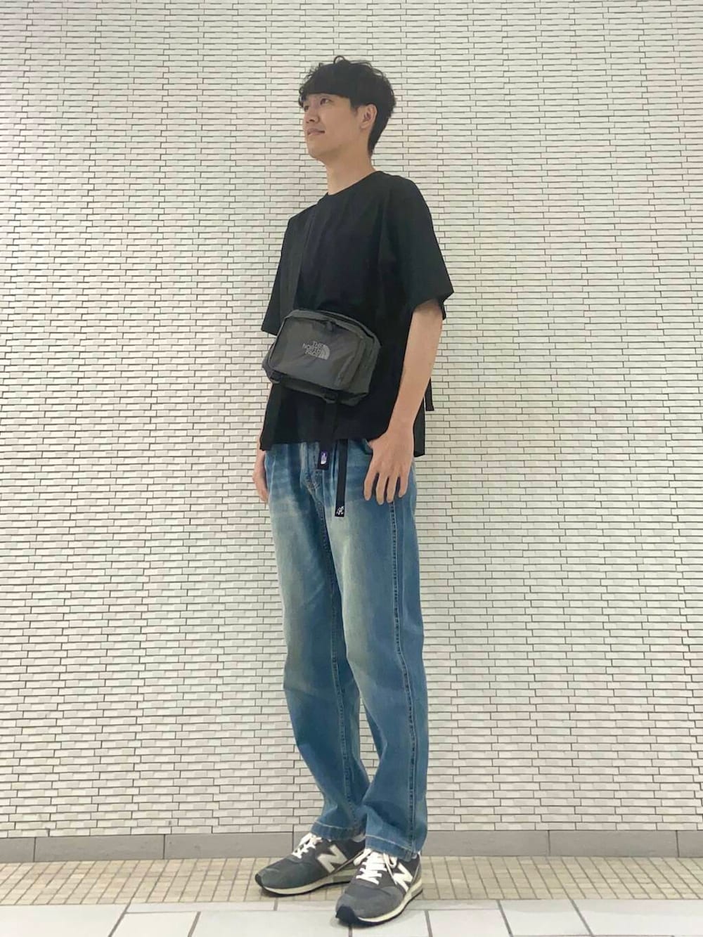 ブラック系のTシャツ/カットソー、ブルー系のデニムパンツ、グレー系のスニーカーを着用したメンズの夏コーディネートの2枚目の写真