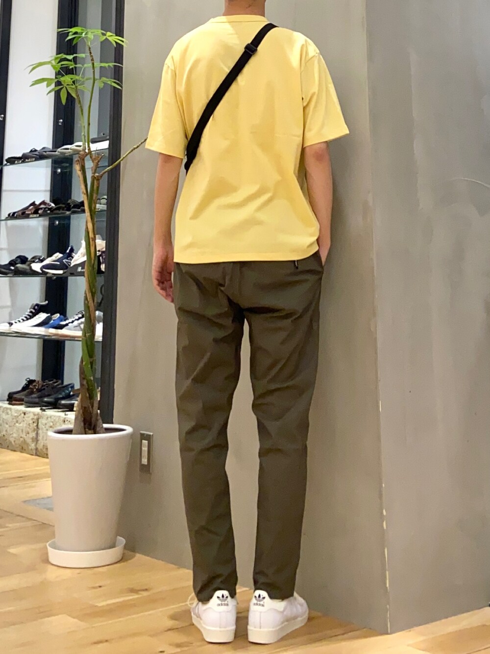イエロー系のTシャツ/カットソー、ブラック系のショルダーバッグ、グリーン系のその他パンツを着用したメンズの春コーディネートの3枚目の写真