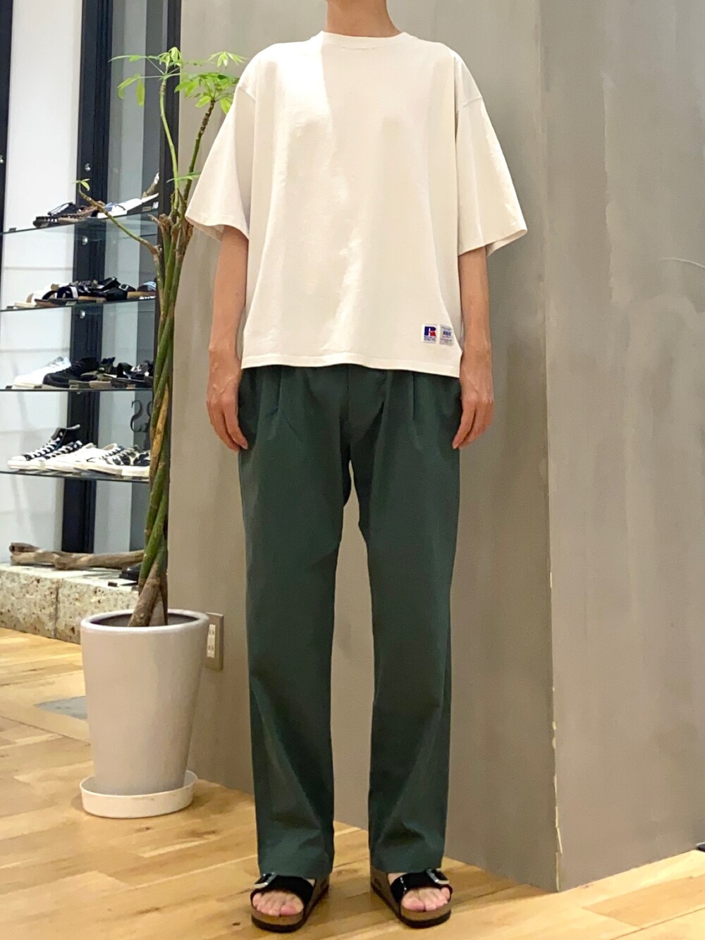 ホワイト系のTシャツ/カットソー、グリーン系のその他パンツ、ブラック系のサンダルを着用したメンズの夏コーディネートの3枚目の写真