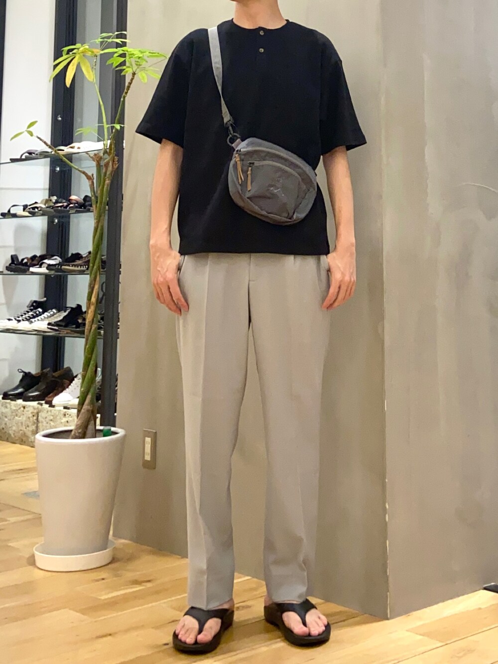 ブラック系のTシャツ/カットソー、グレー系のショルダーバッグ、ブラック系のサンダルを着用したメンズの春コーディネートの3枚目の写真