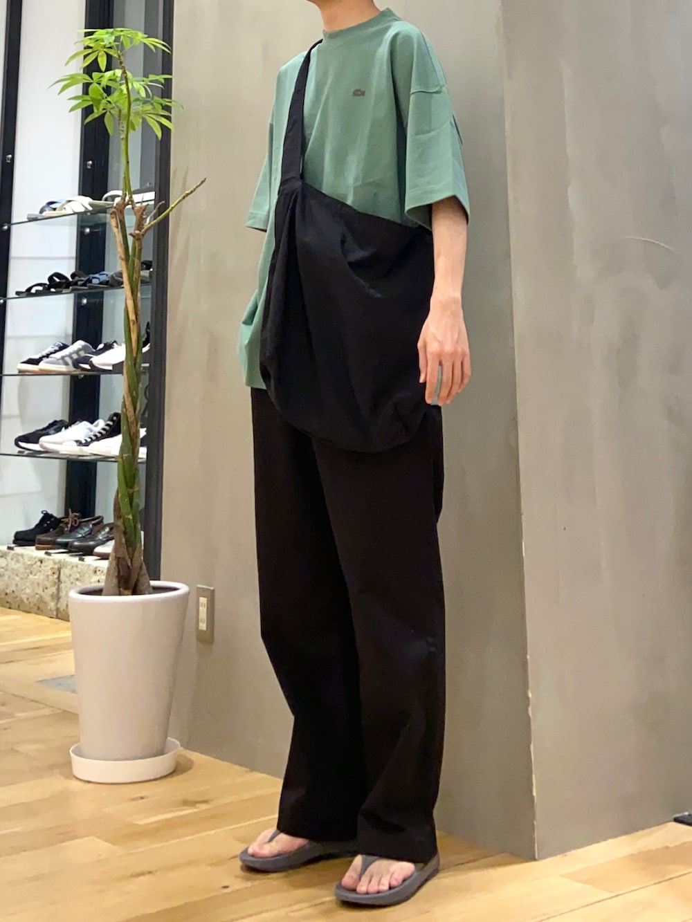 グリーン系のTシャツ/カットソー、ブラック系のショルダーバッグ、ブラック系のその他パンツを着用したメンズの春コーディネートの2枚目の写真