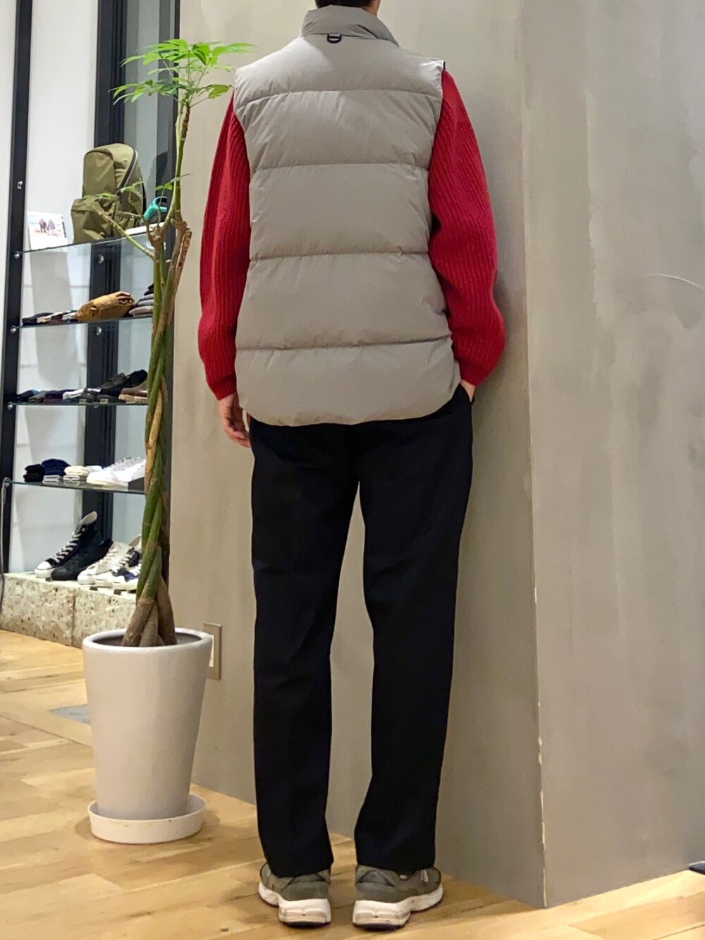 グレー系のダウンベスト、レッド系のニット/セーター、ブラック系のその他パンツを着用したメンズの冬コーディネートの4枚目の写真