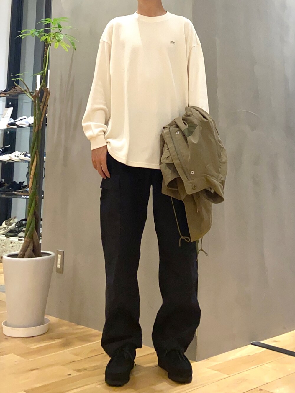 グリーン系のモッズコート、ホワイト系のTシャツ/カットソー、ブラック系のその他パンツを着用したメンズの秋コーディネートの2枚目の写真