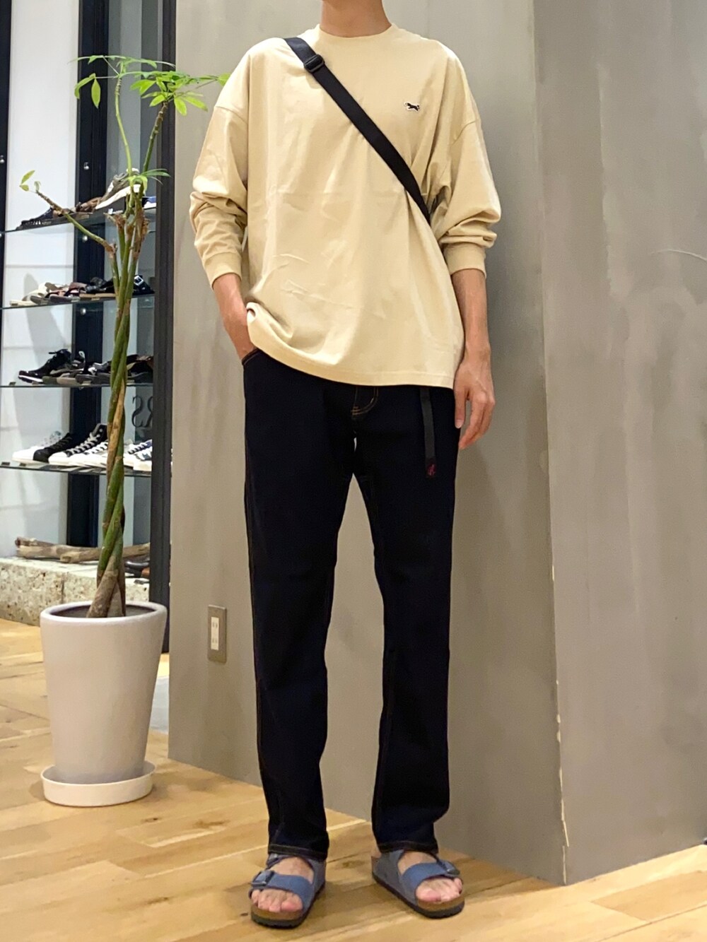 ベージュ系のTシャツ/カットソー、ブルー系のその他パンツ、ブルー系のサンダルを着用したメンズの秋コーディネートの3枚目の写真