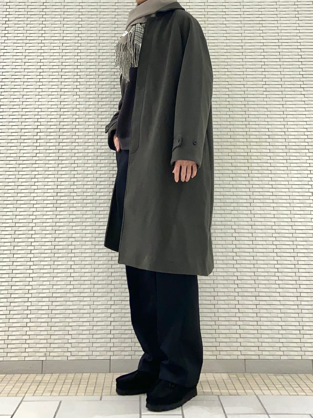 グリーン系のステンカラーコート、グレー系のTシャツ/カットソー、ブラック系のその他パンツを着用したメンズの冬コーディネートの2枚目の写真