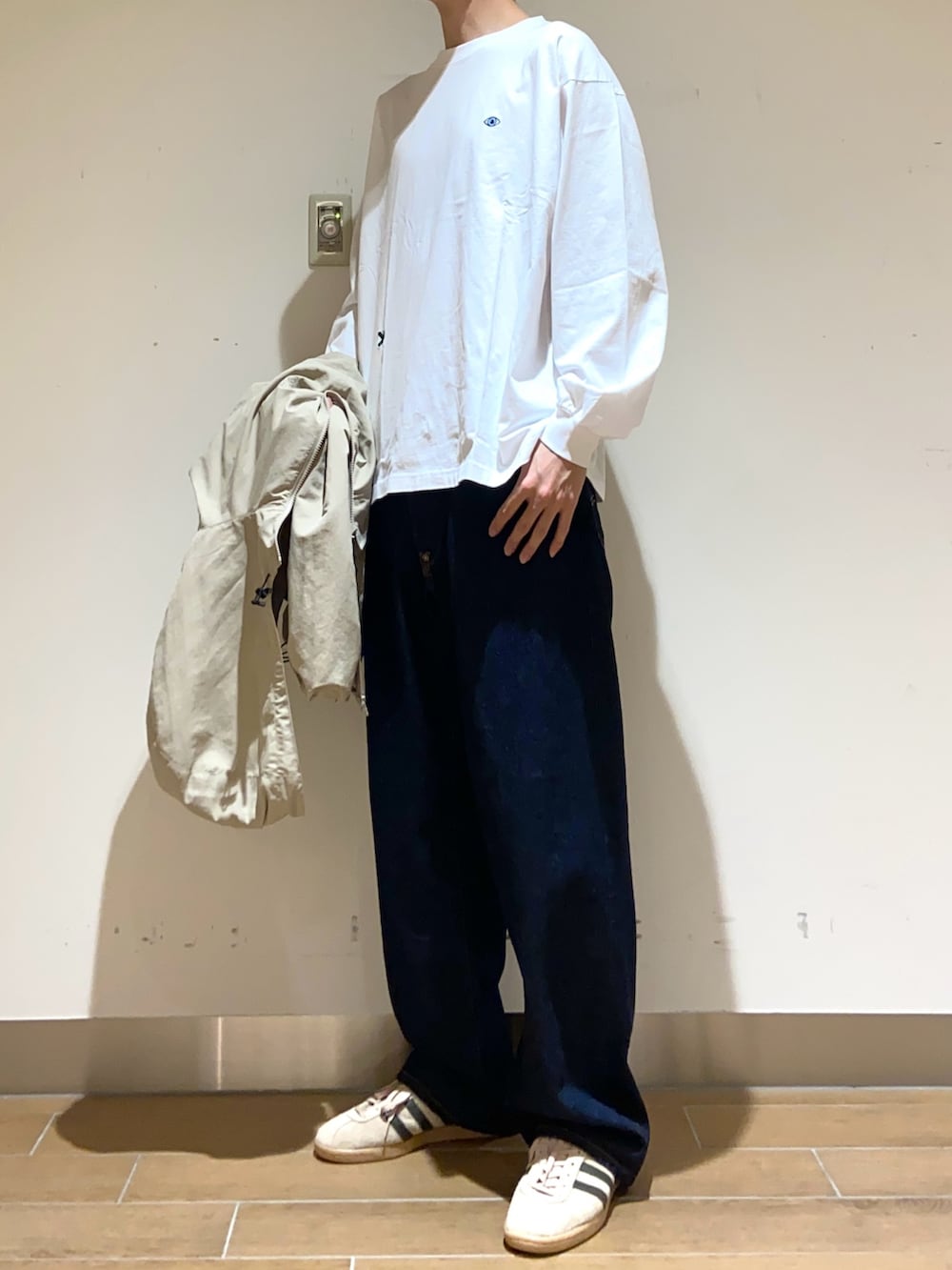 ベージュ系のマウンテンパーカー、ホワイト系のTシャツ/カットソー、ブルー系のデニムパンツを着用したメンズの春コーディネートの4枚目の写真