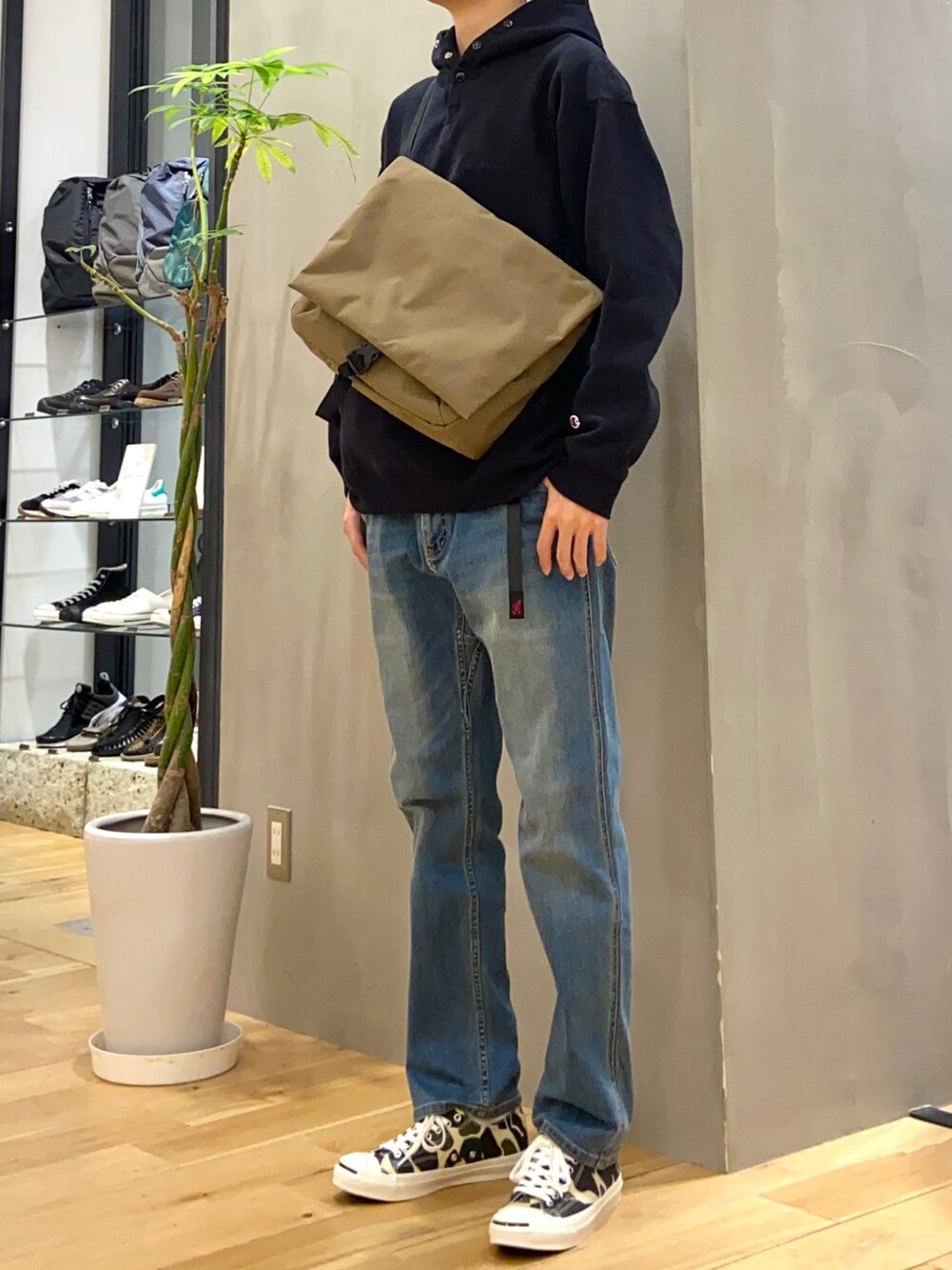 ブラック系のパーカー、ベージュ系のショルダーバッグ、ブルー系のその他パンツを着用したメンズの秋コーディネートの2枚目の写真