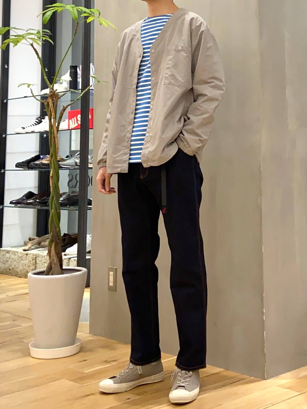 グレー系のナイロンジャケット、ホワイト系のTシャツ/カットソー、グレー系のスニーカーを着用したメンズの春コーディネートの4枚目の写真