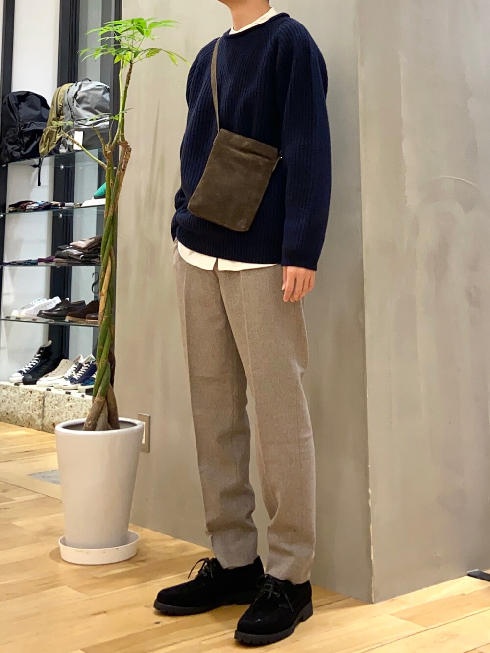 ブルー系のニット/セーター、ブラウン系のショルダーバッグ、ブラック系のその他シューズを着用したメンズの冬コーディネートの2枚目の写真