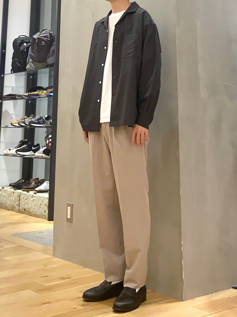 ベージュ系のスラックス、ブラック系のローファー、グレー系のシャツ/ブラウスを着用したメンズの春コーディネートの2枚目の写真